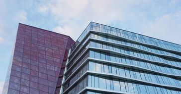 A tall building with a lot of windows and a blue sky in the background.