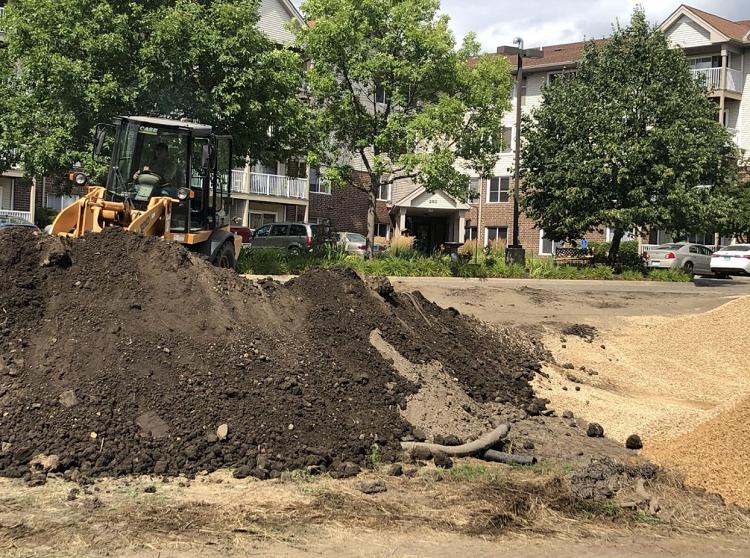 A large pile of dirt is being moved by a bulldozer.
