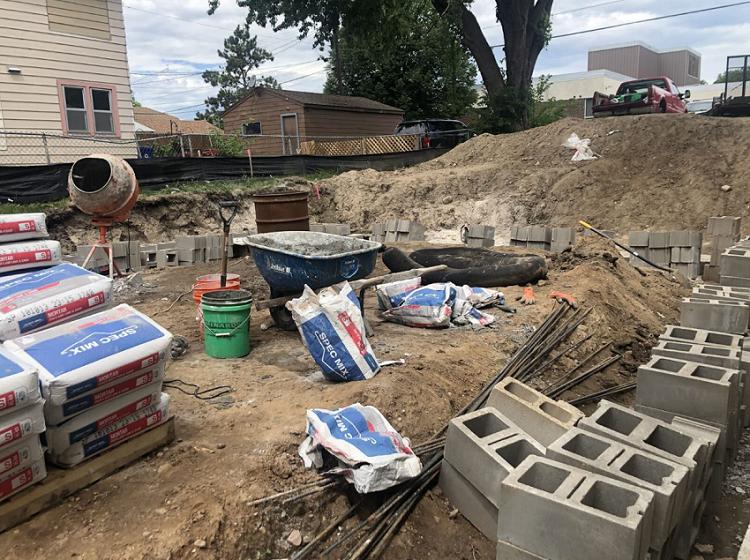 A pile of concrete blocks and bags of cement on a construction site