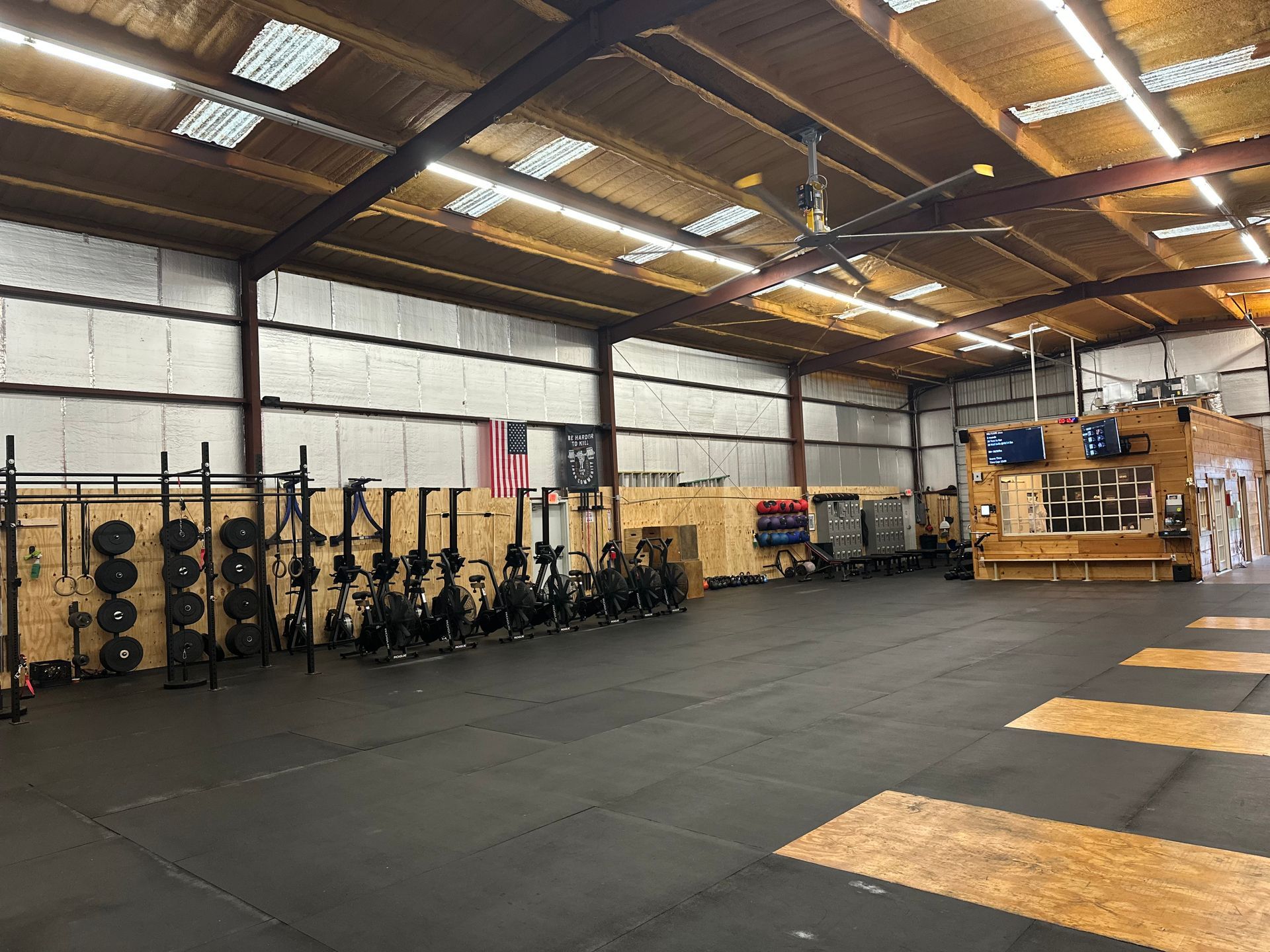 Inside a large gym, filled with fitness equipment. Includes weights, rowing machines, and workout stations, all against the walls.