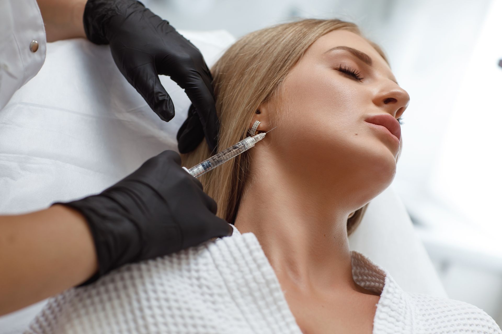A woman is getting a botox injection in her neck.