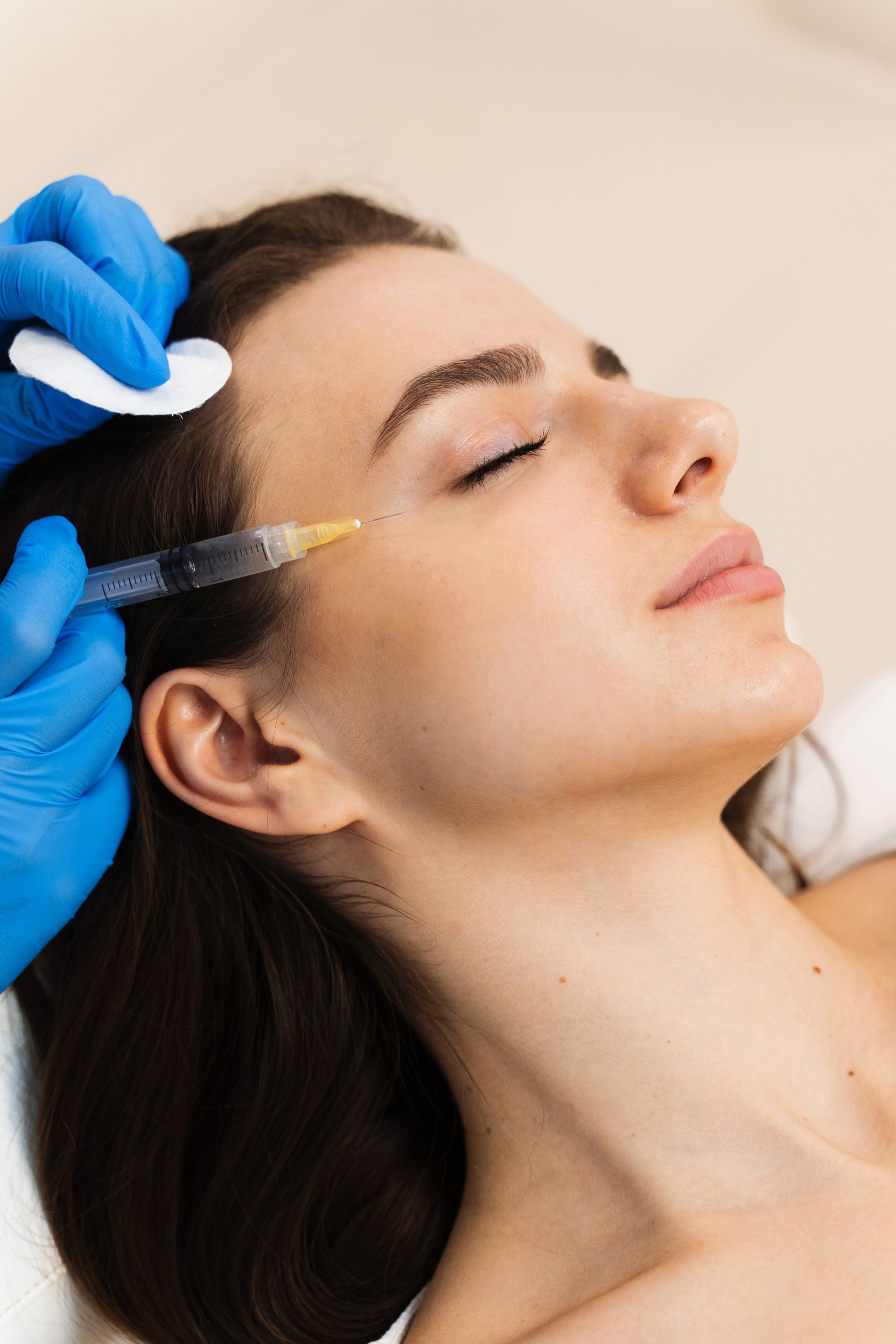 A woman is getting a botox injection in her face.