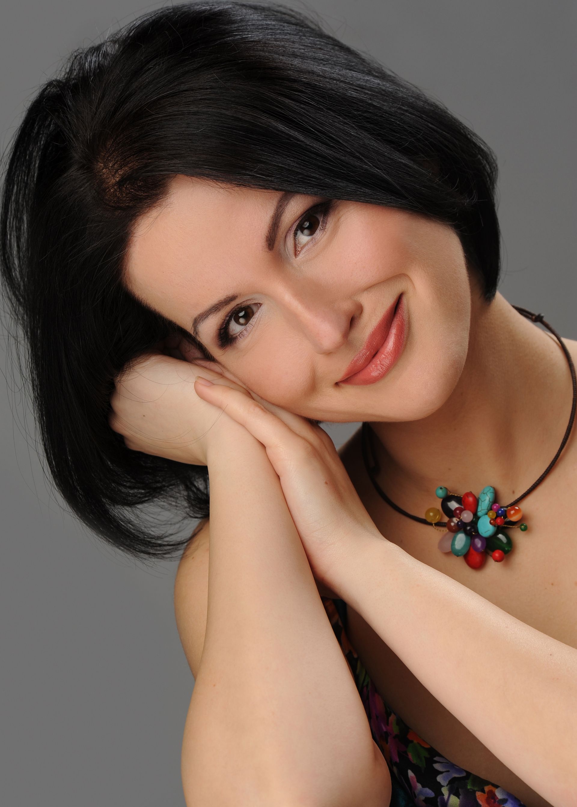 A woman wearing a necklace with a flower on it