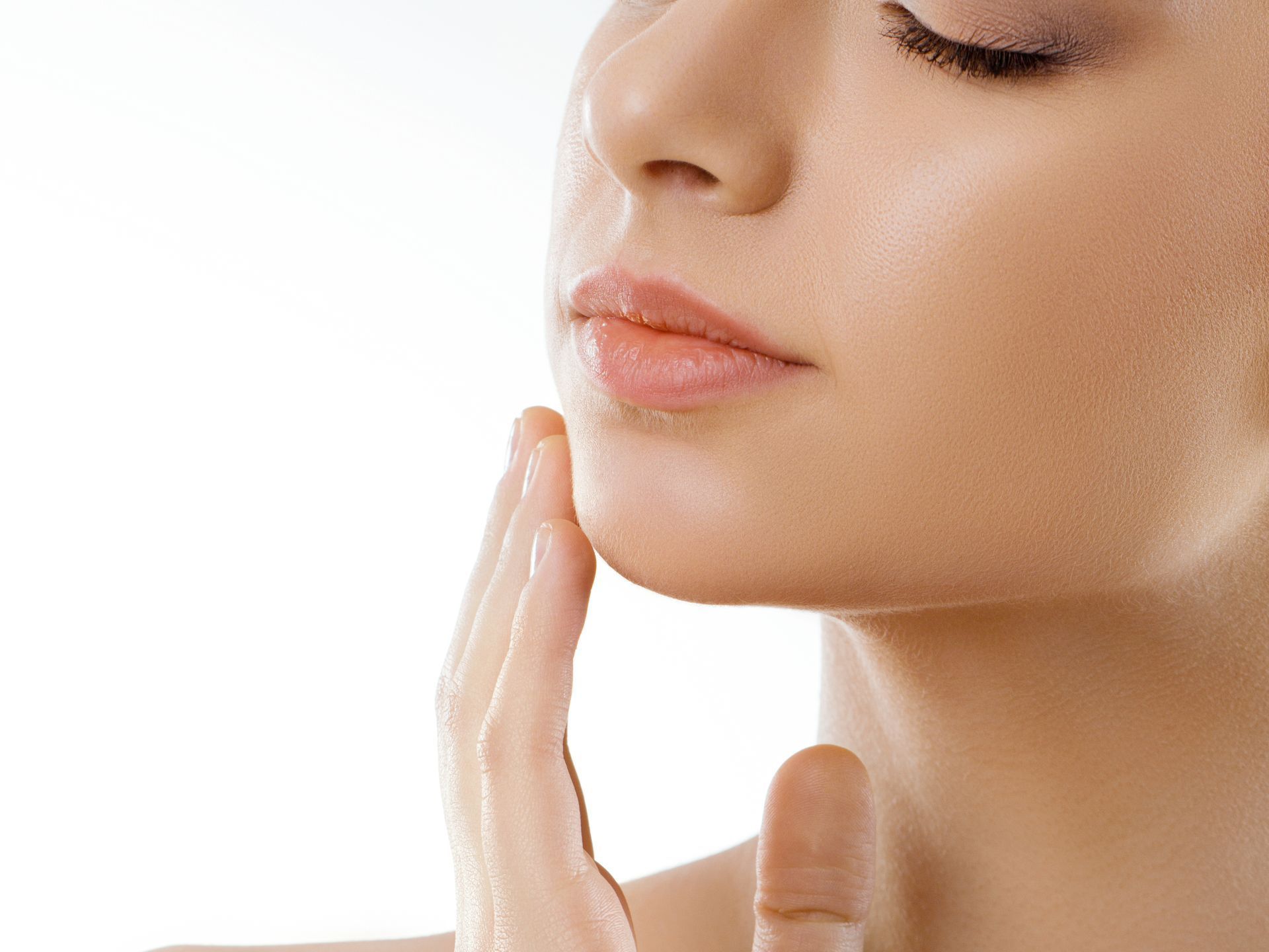 A close up of a woman 's face with her hand on her chin.