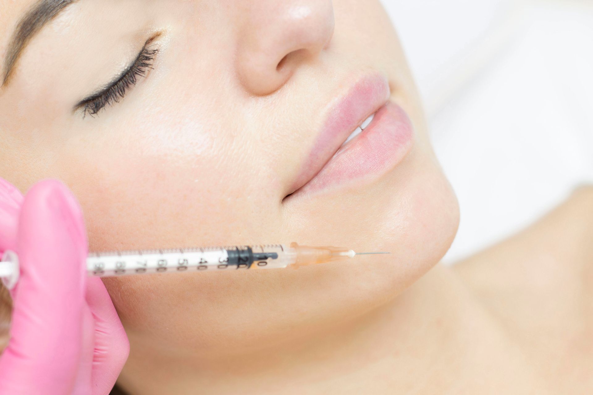 A woman is getting a botox injection in her face.