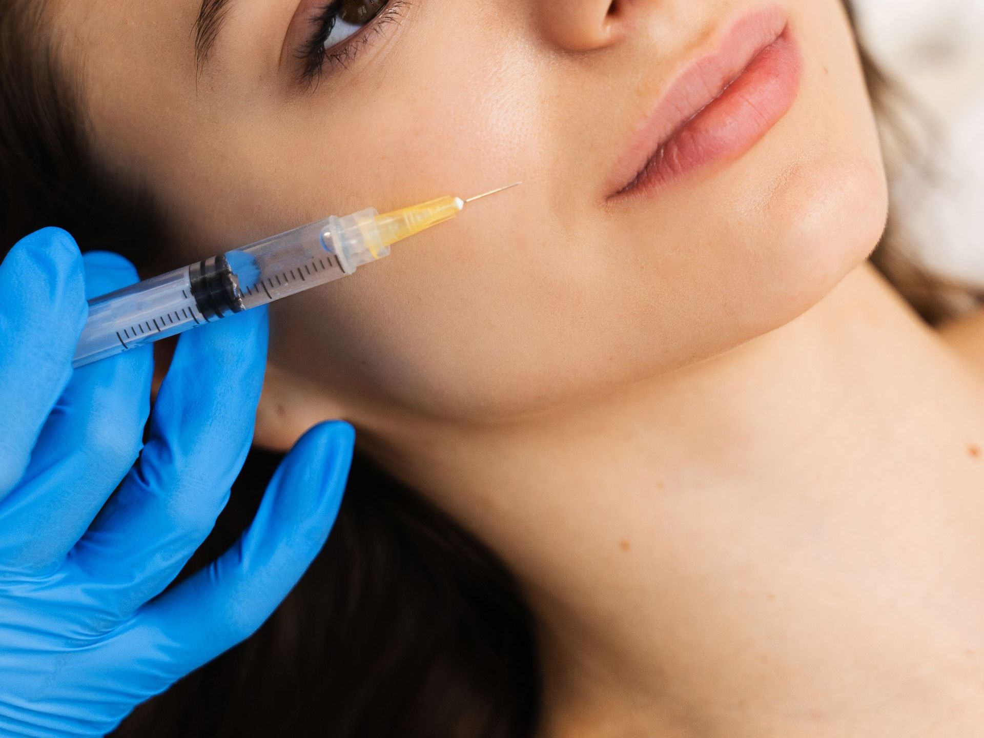 A woman is getting a botox injection in her face.