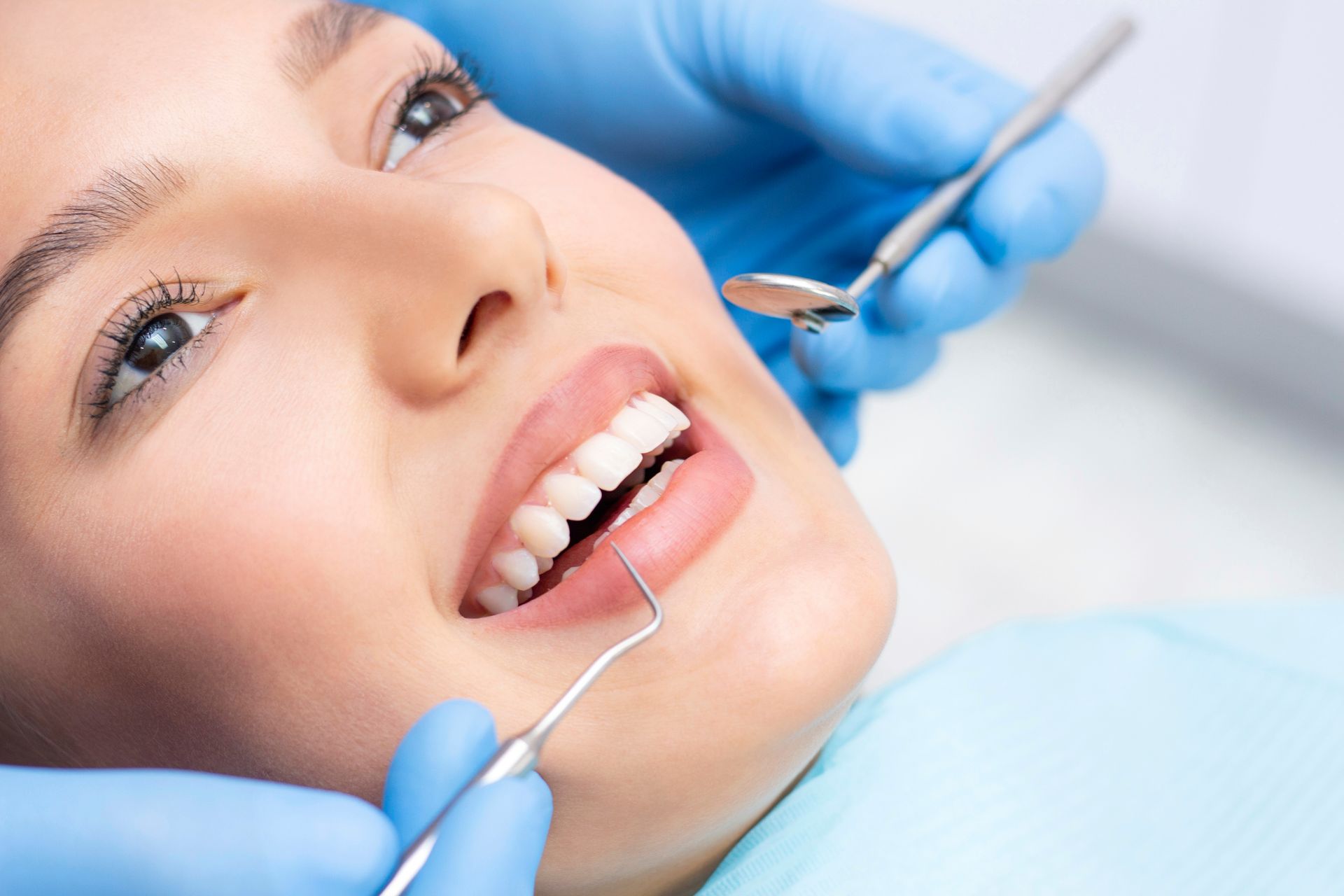 A woman is getting her teeth examined by a dentist.