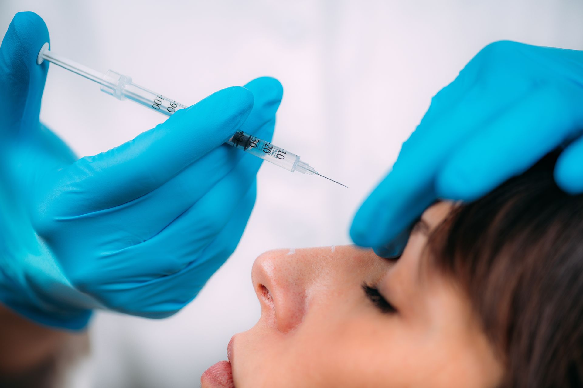 A woman is getting a botox injection in her eye.