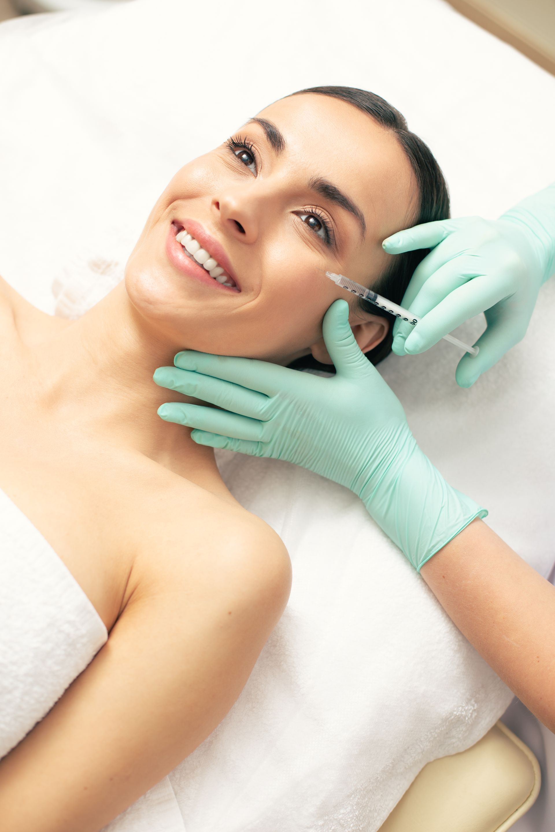 A woman is getting an injection in her face in a beauty salon.