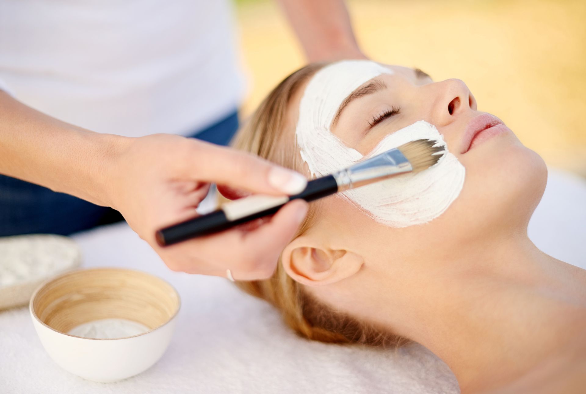 A woman is getting a facial treatment at a spa.