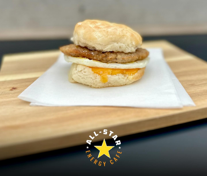 A sausage egg and cheese biscuit sandwich on a wooden cutting board