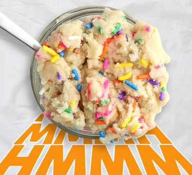 A bowl of cookie dough with sprinkles and a spoon