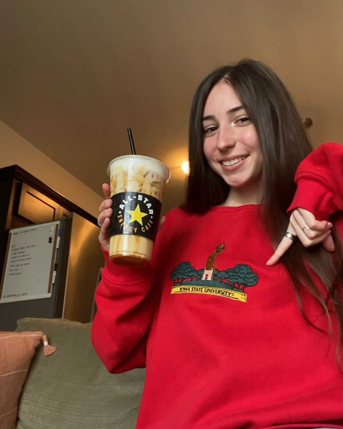 A girl in a red sweater is holding a cup of coffee