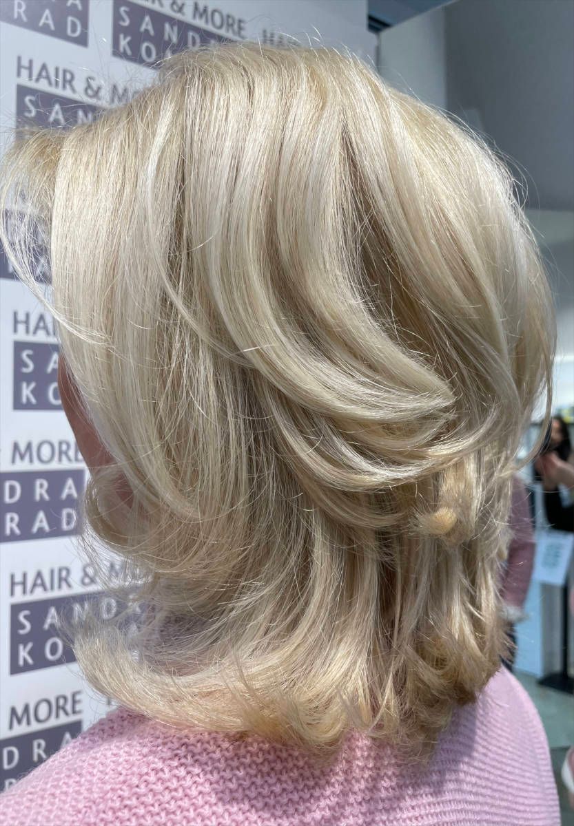 Junge Frau mit mittellangen silber-rosa farbenen Haaren und Rosa Blazer