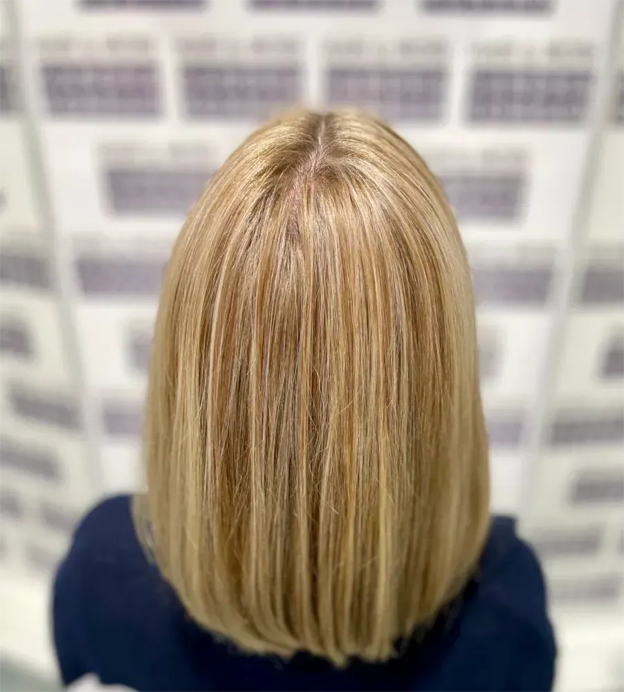 Blondes Haar mit Strähnchen, schulterlang, von hinten gesehen.