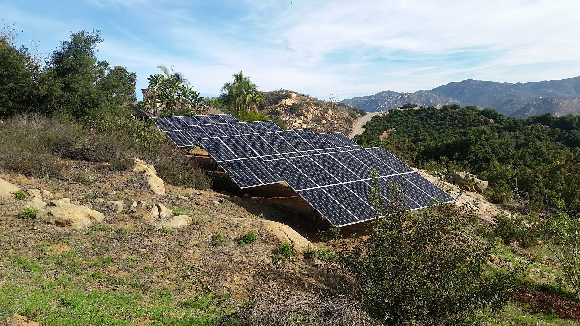 A row of solar panels are sitting on top of a hill.