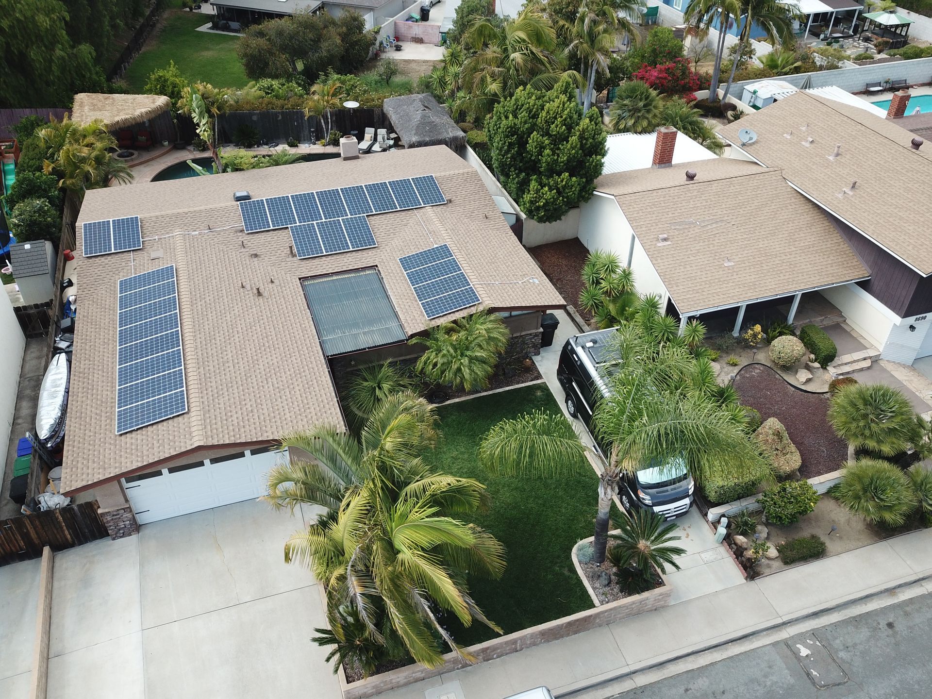 An aerial view of a house with solar panels on the roof