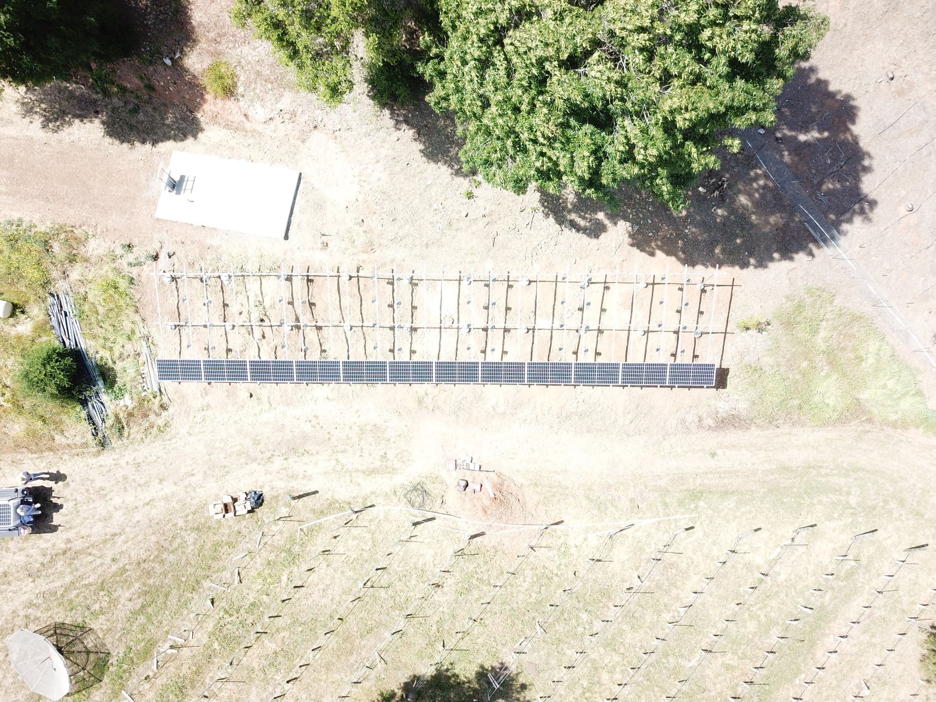 An aerial view of a field with trees in the background.