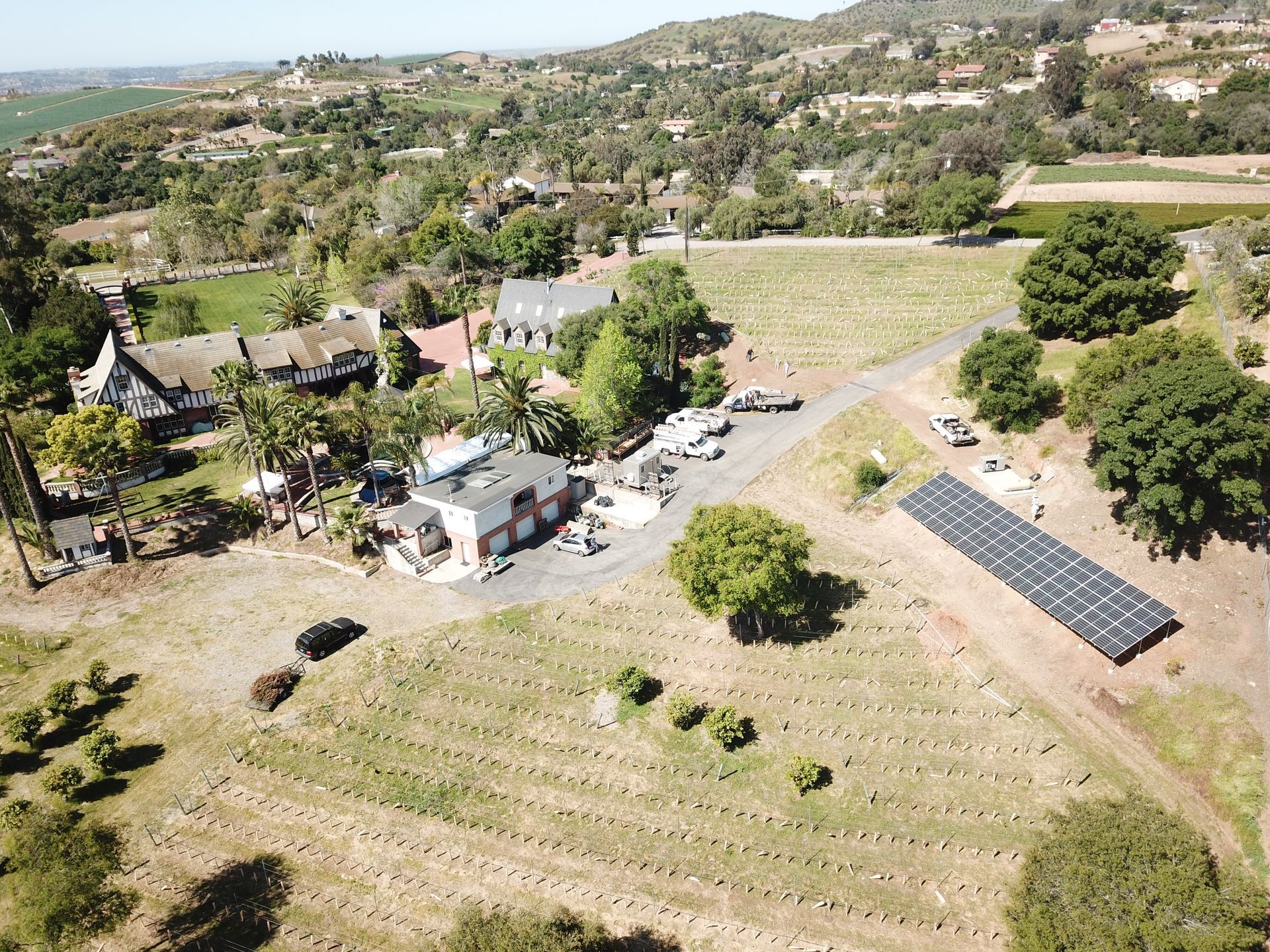 An aerial view of a farm with a lot of trees and houses.