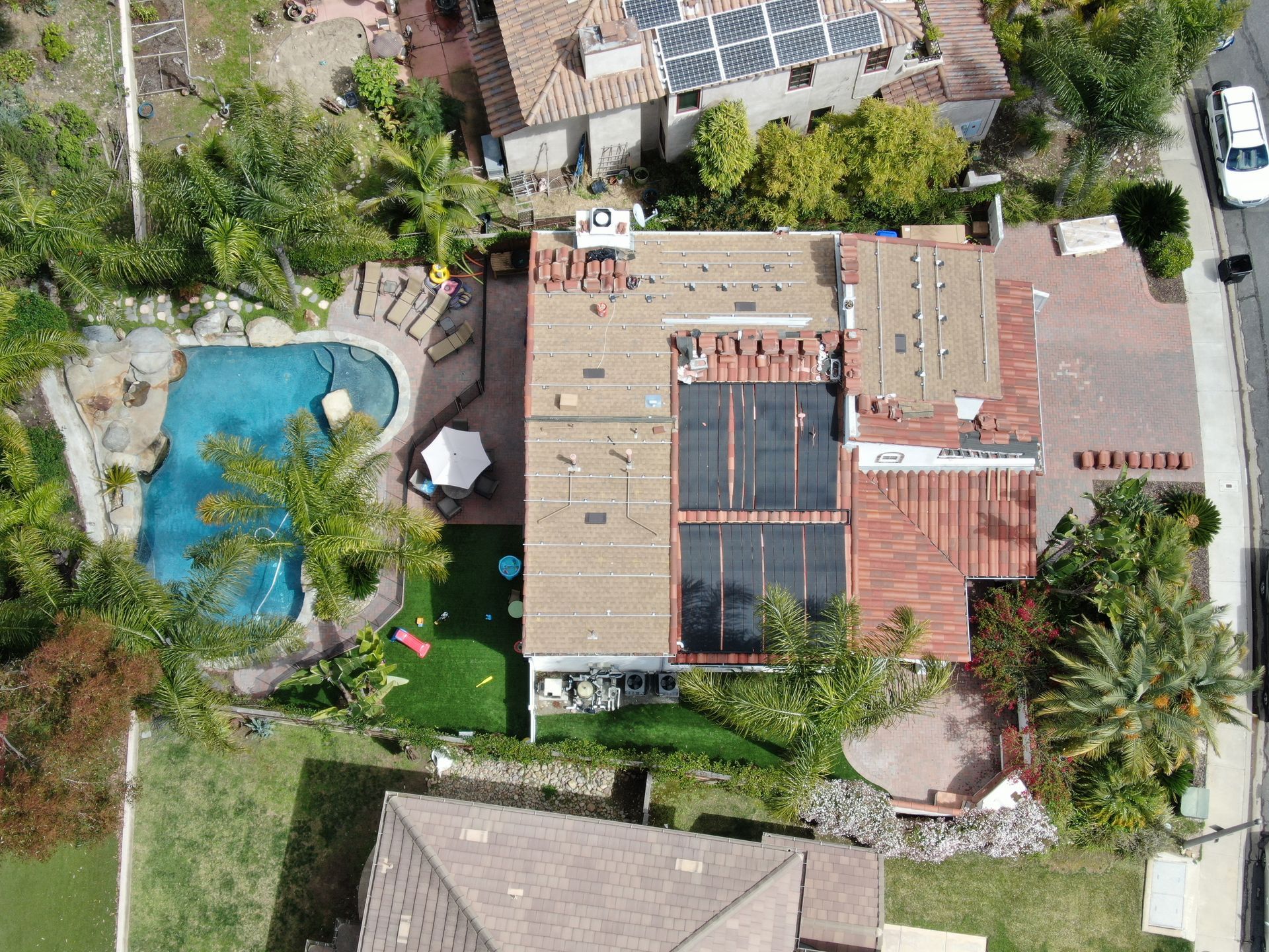 An aerial view of a house with a pool and solar panels on the roof.