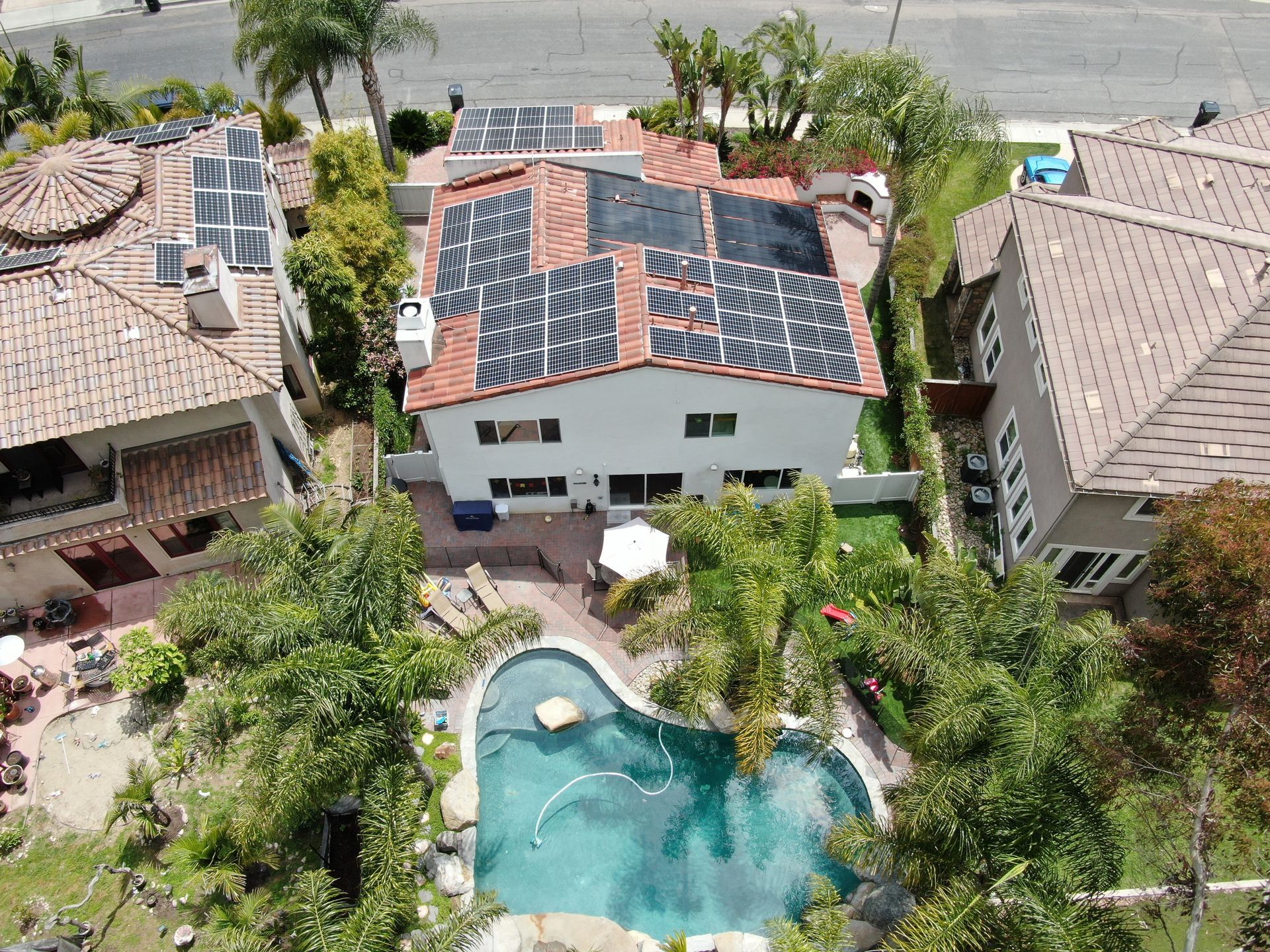 An aerial view of a house with a pool and solar panels on the roof.
