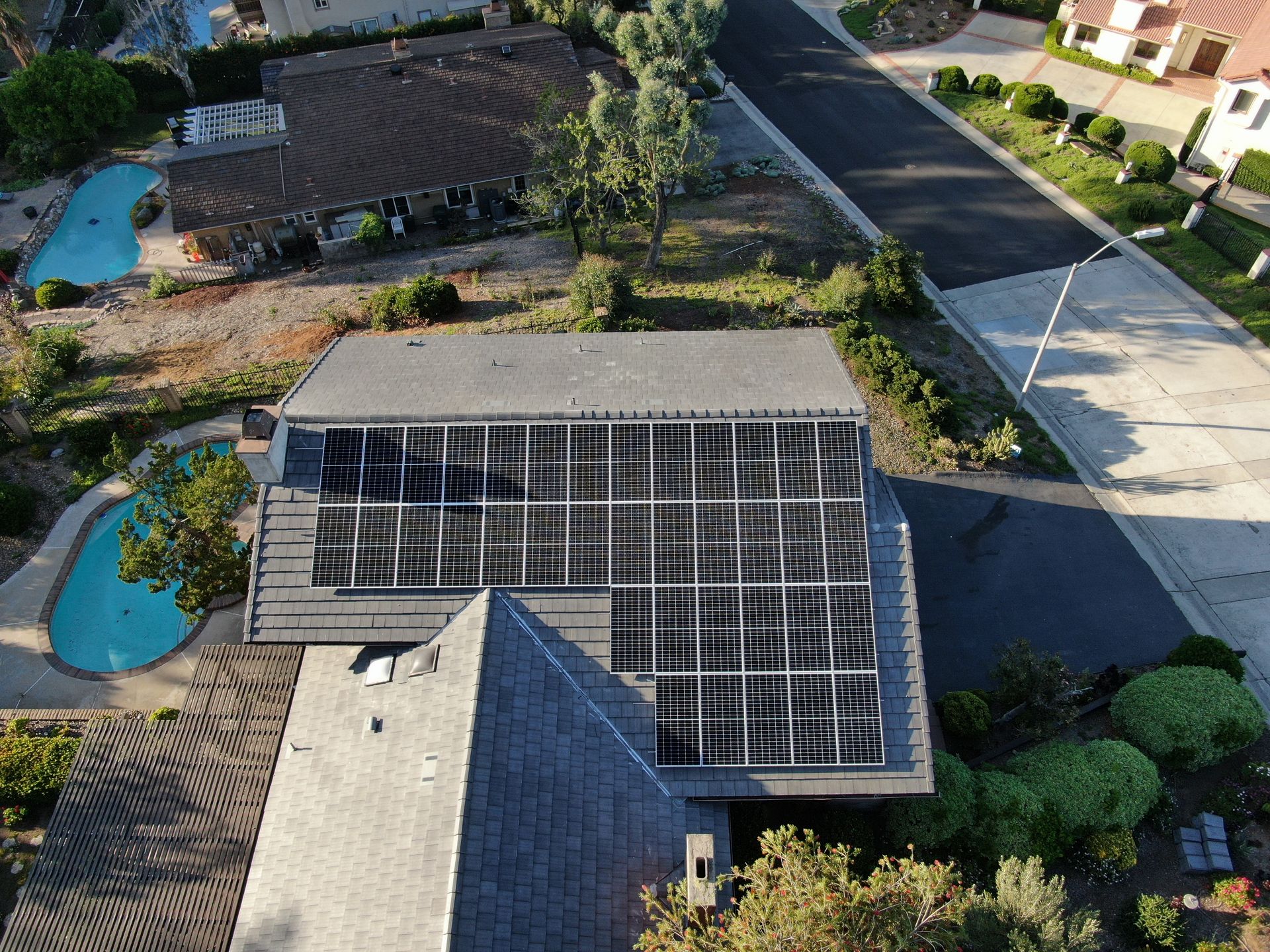 An aerial view of a house with solar panels on the roof.