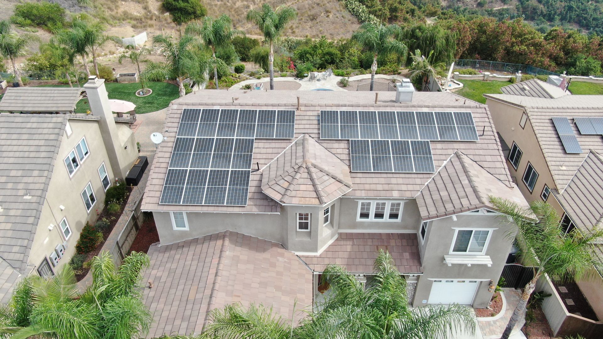 An aerial view of a house with solar panels on the roof