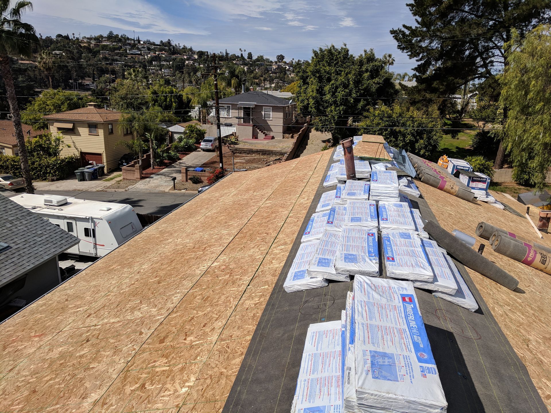 A roof with a lot of bags of shingles on it.