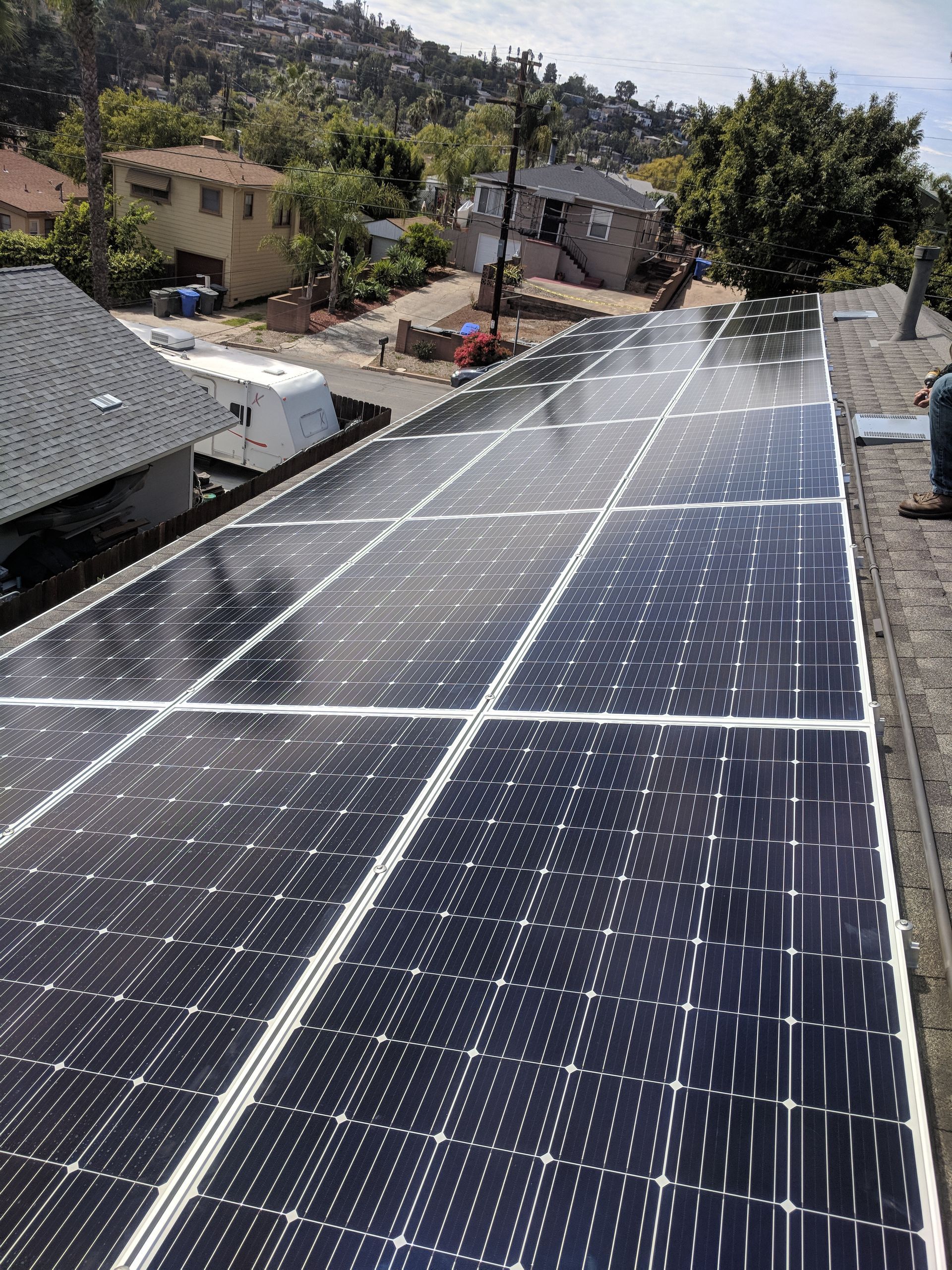 A row of solar panels are sitting on top of a roof.