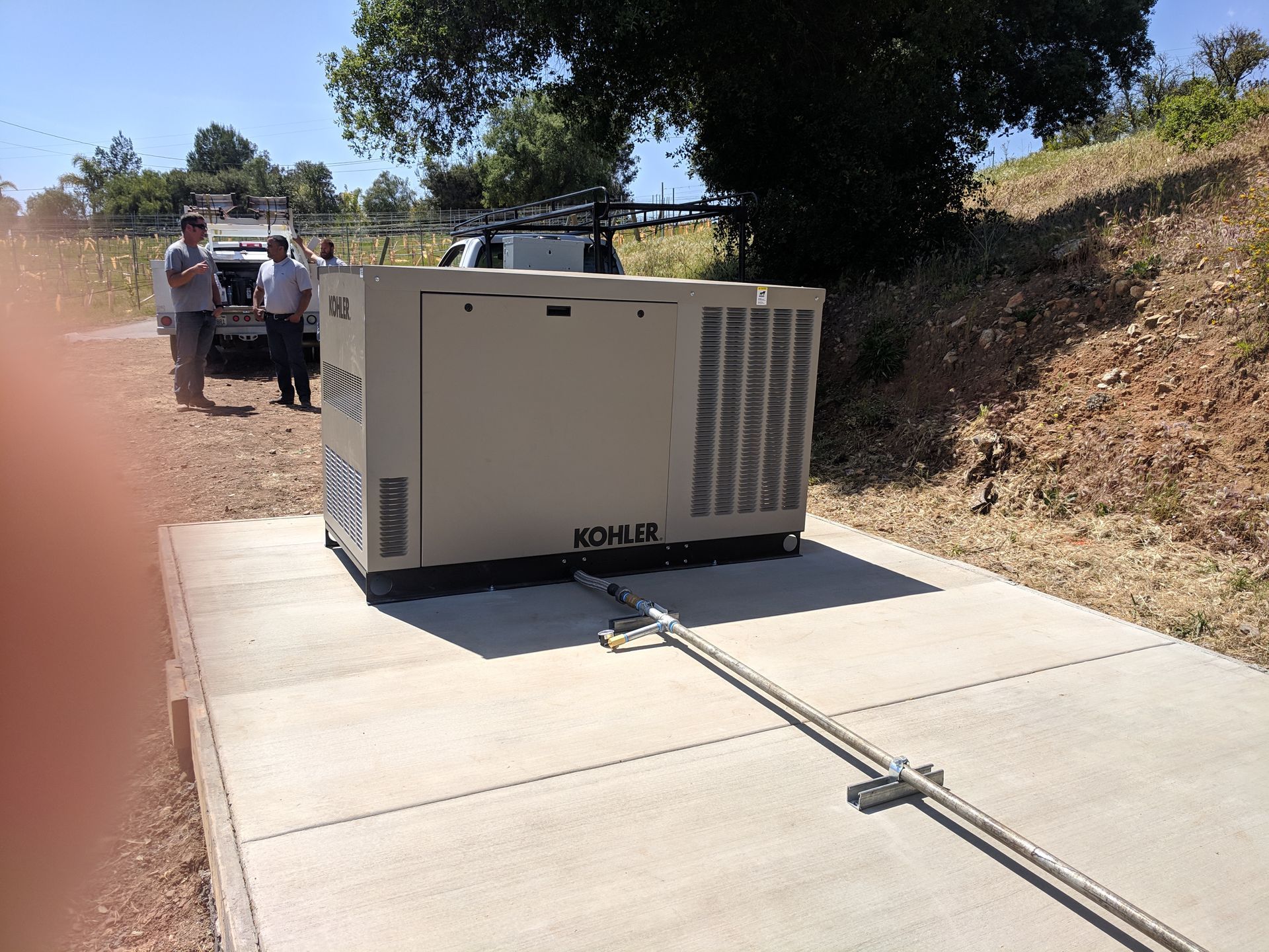 A group of people standing around a generator that says komw on it