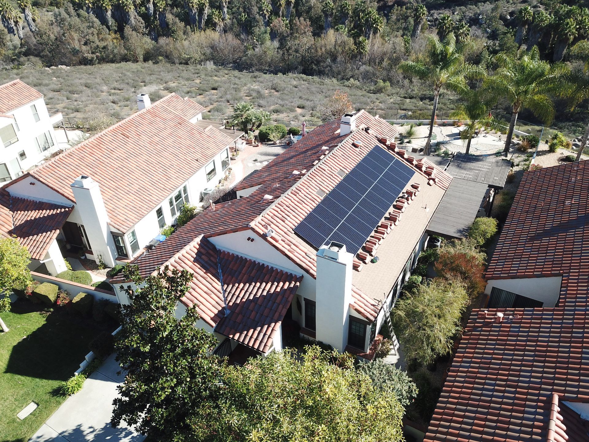 An aerial view of a house with solar panels on the roof