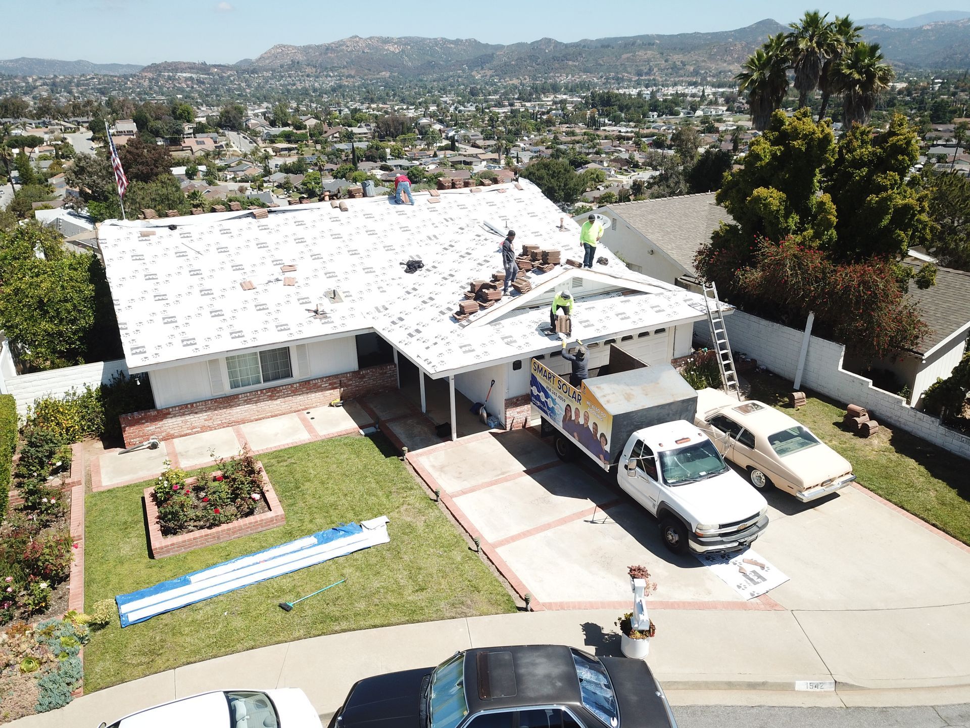 An aerial view of a house being remodeled with a truck parked in front of it.