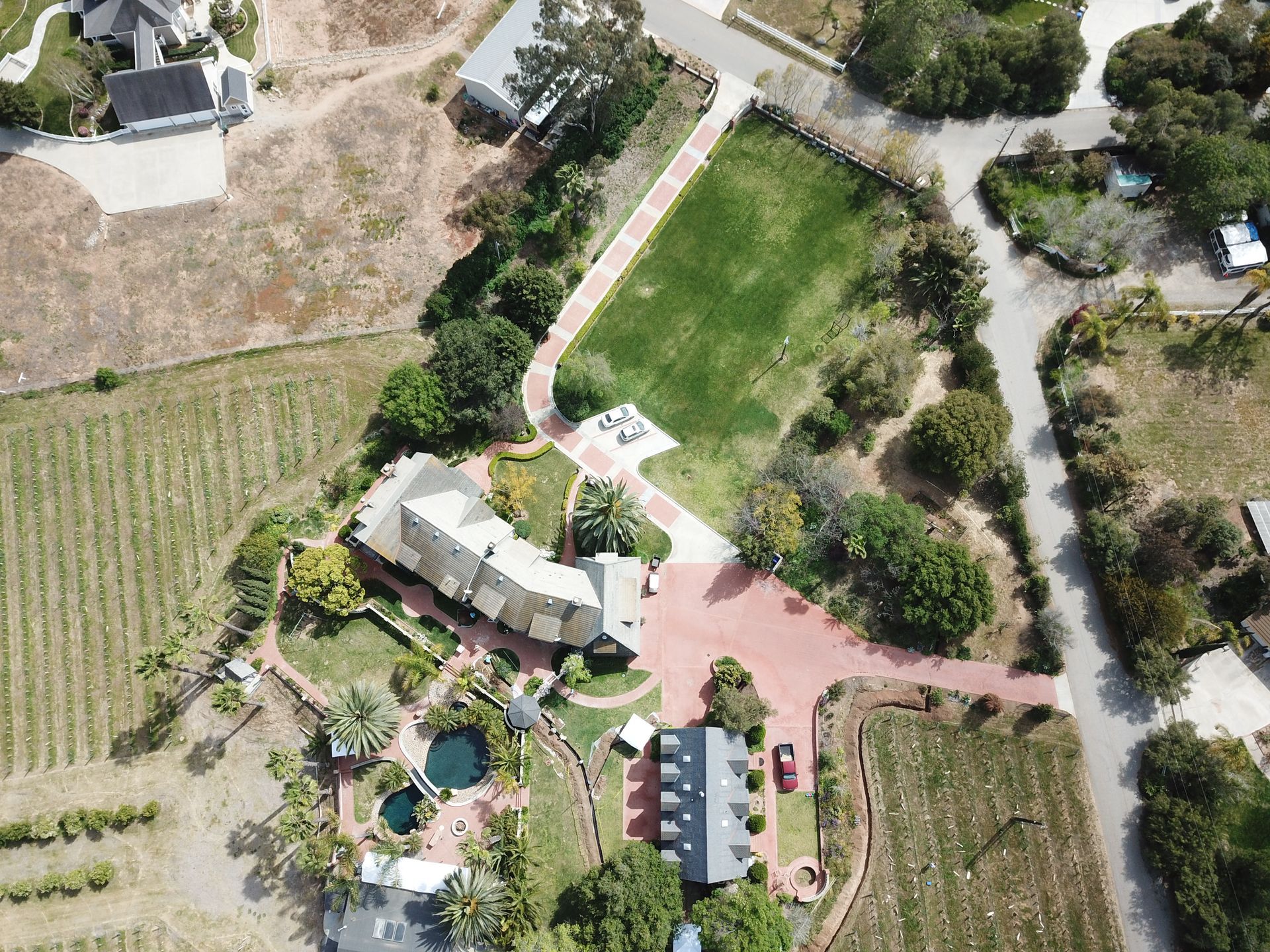An aerial view of a house surrounded by fields and trees