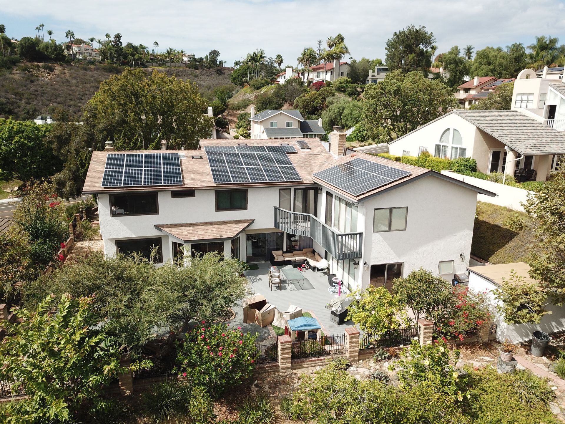 An aerial view of a house with solar panels on the roof.