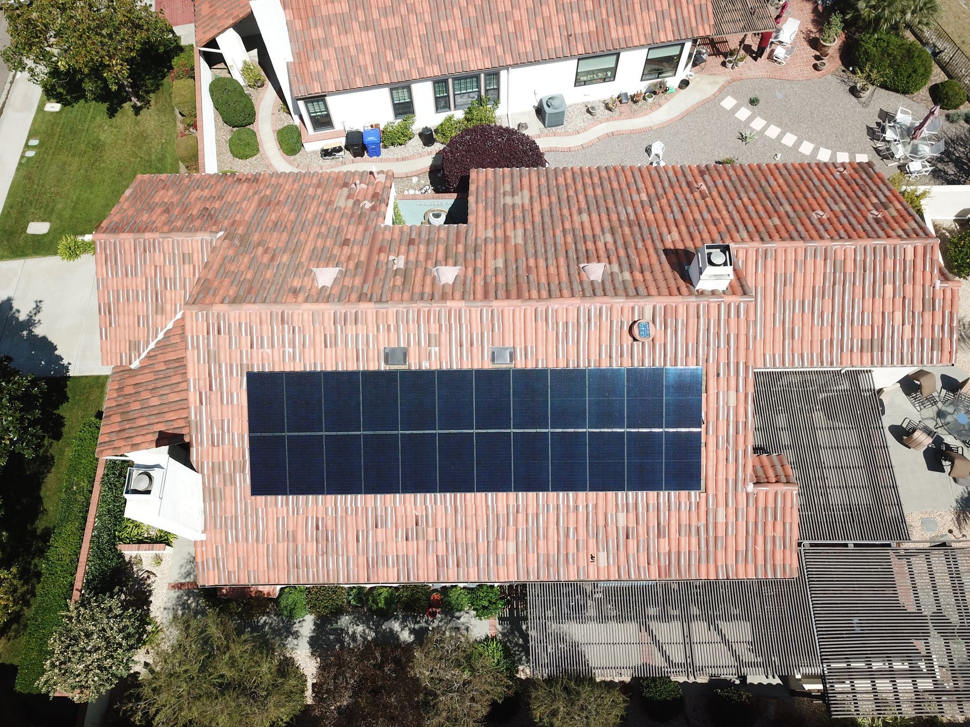 An aerial view of a house with solar panels on the roof