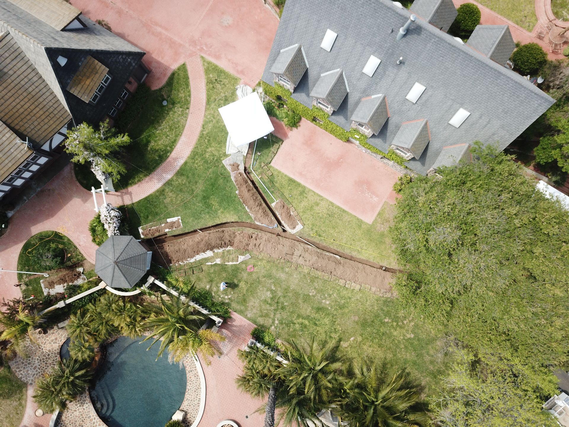 An aerial view of a house with a pool and palm trees