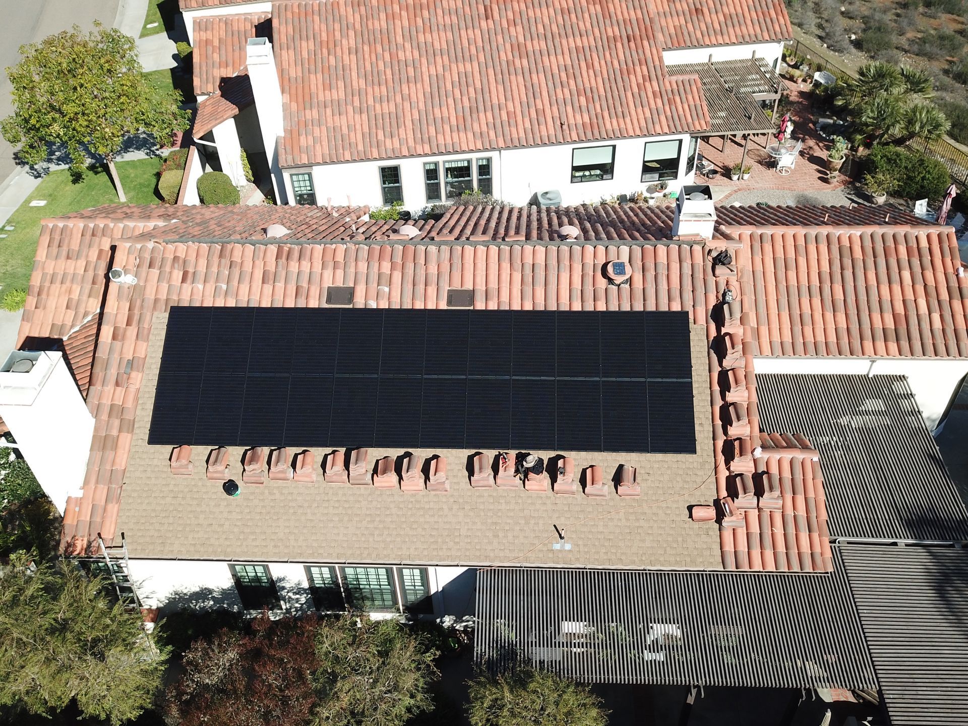 An aerial view of a house with solar panels on the roof