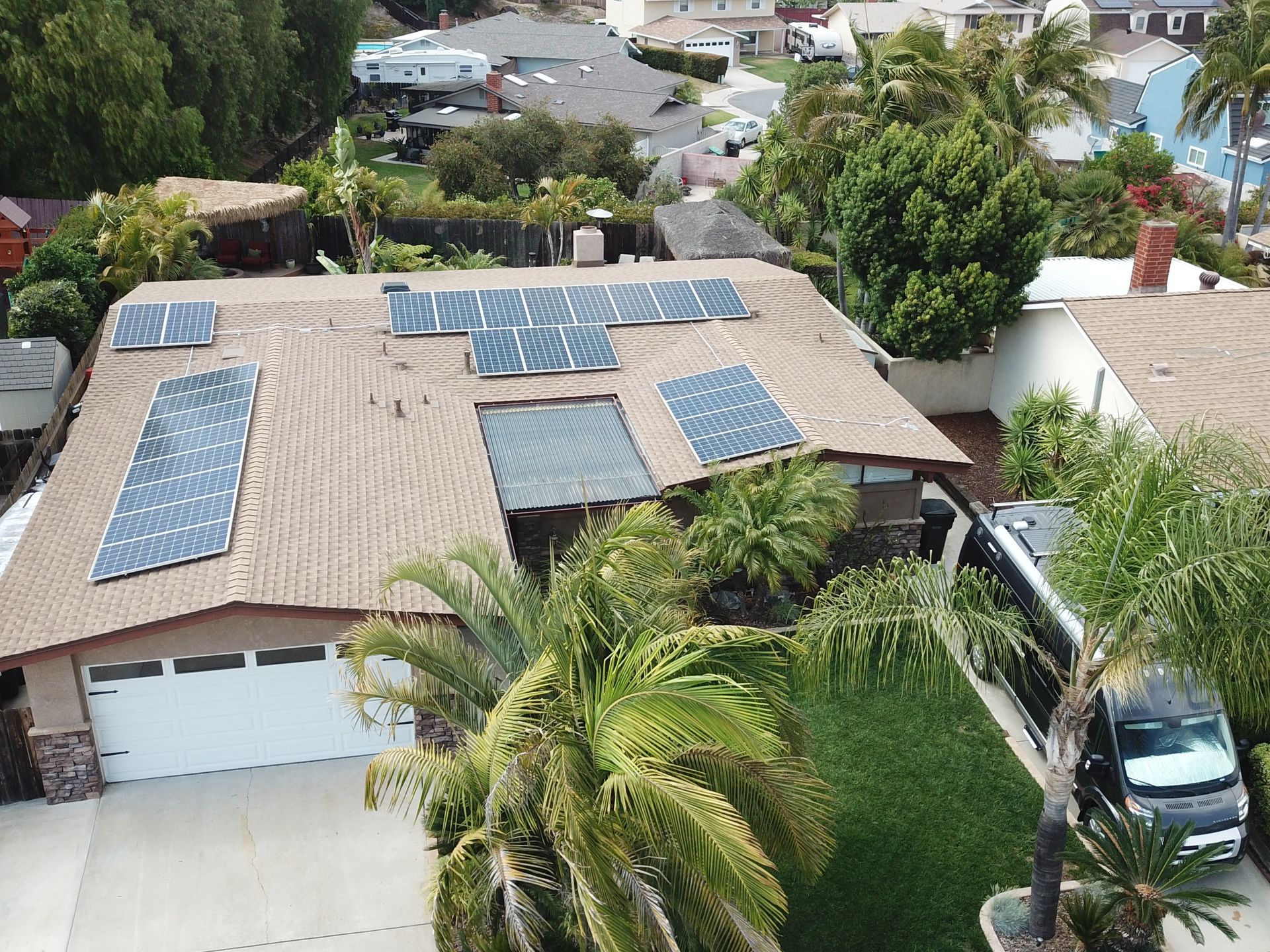 An aerial view of a house with solar panels on the roof.