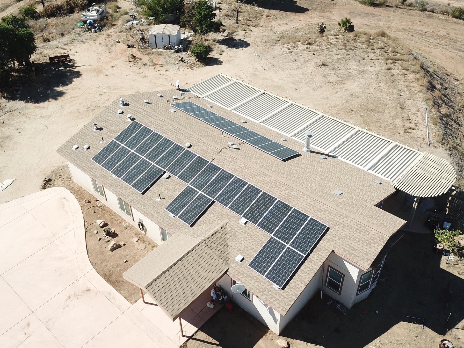 An aerial view of a house with solar panels on the roof.