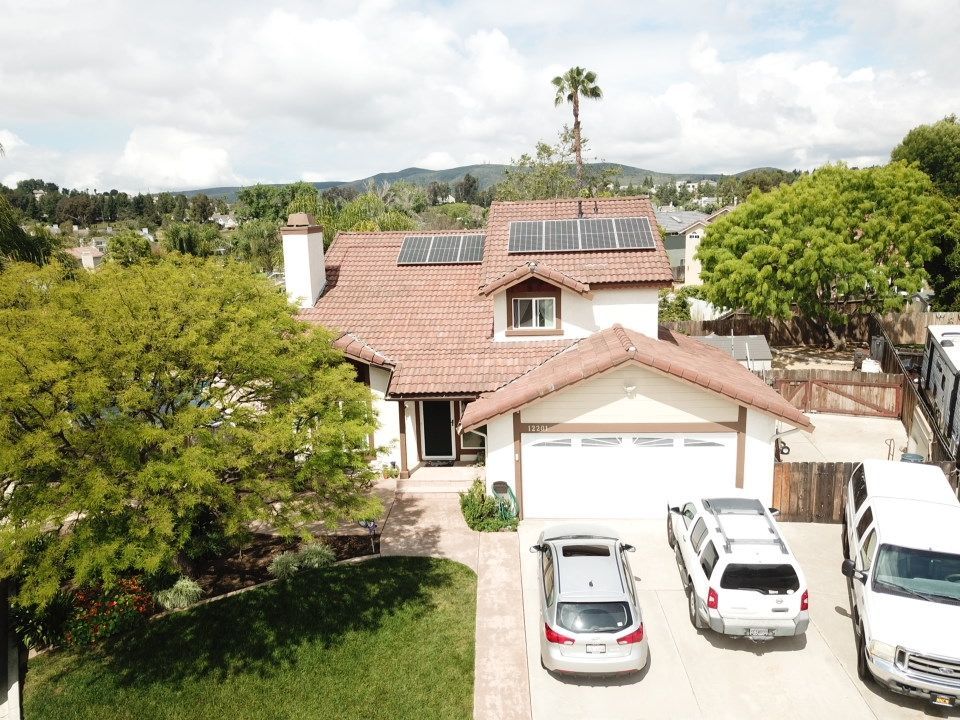 An aerial view of a house with a lot of cars parked in front of it.