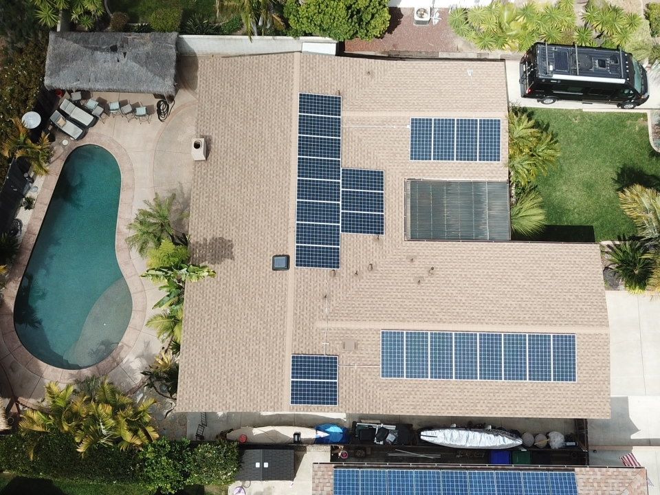 An aerial view of a house with solar panels on the roof