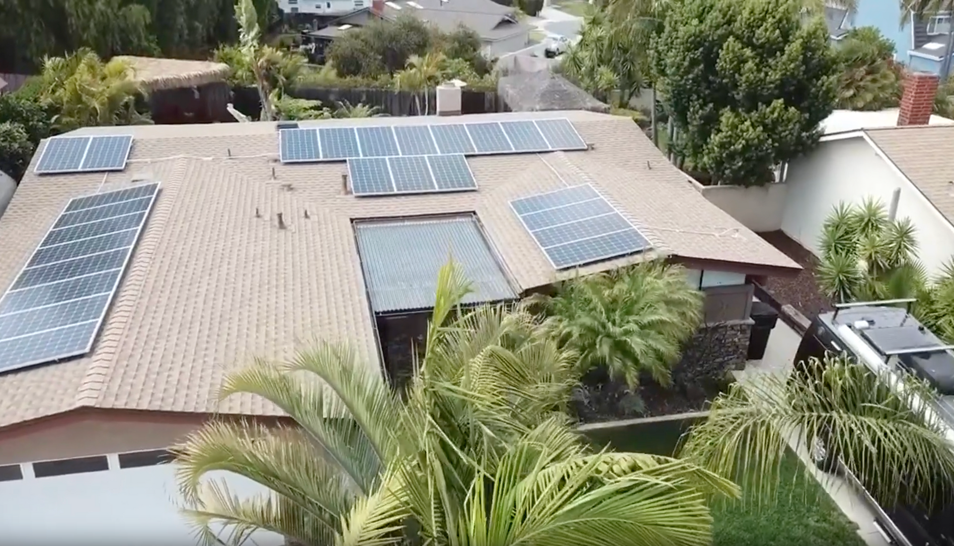 An aerial view of a house with solar panels on the roof.