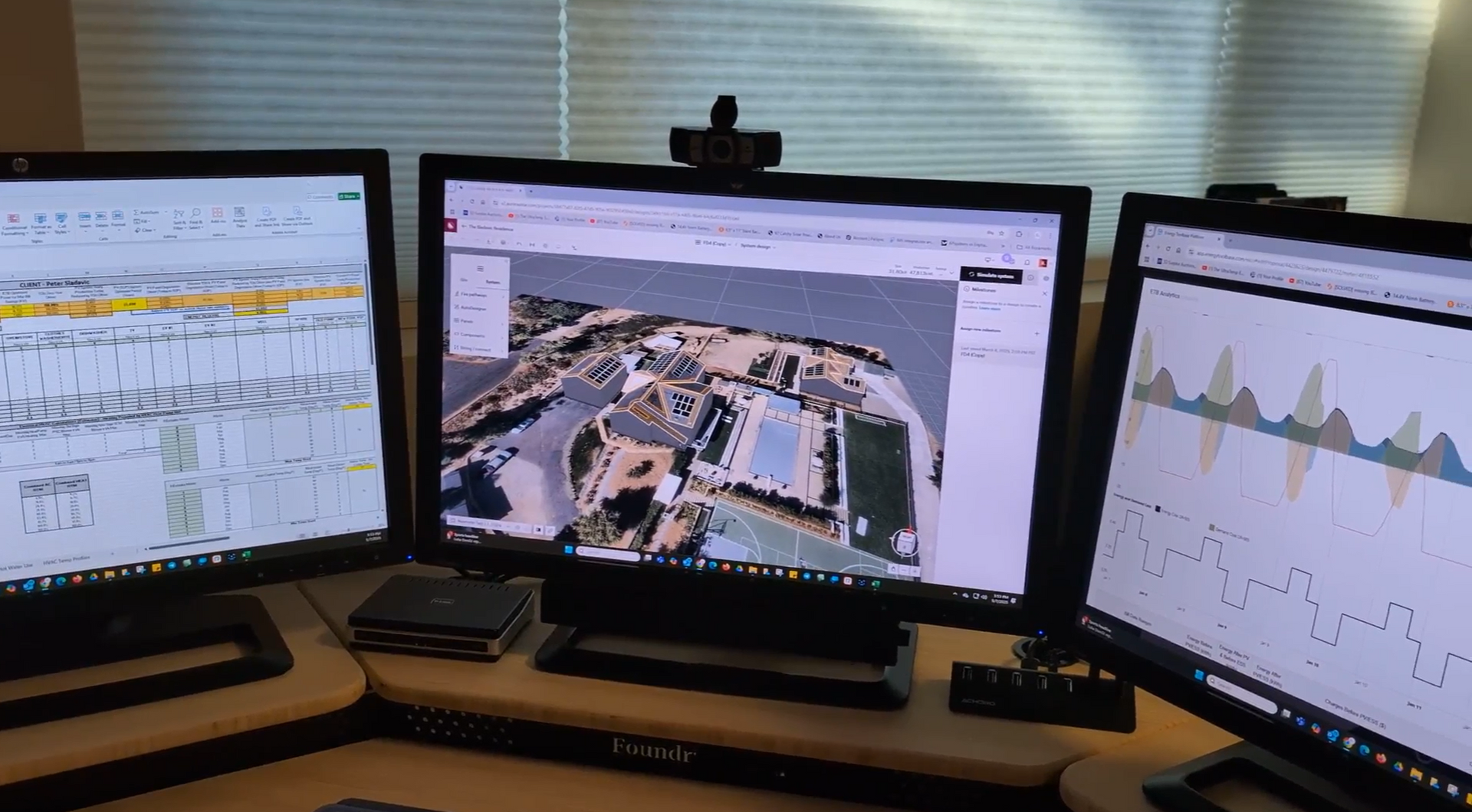Three computer monitors are sitting on a desk with solar system design and energy usage metrics 