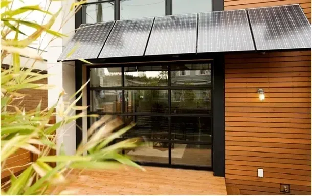 A house with a lot of windows and solar panels on the roof