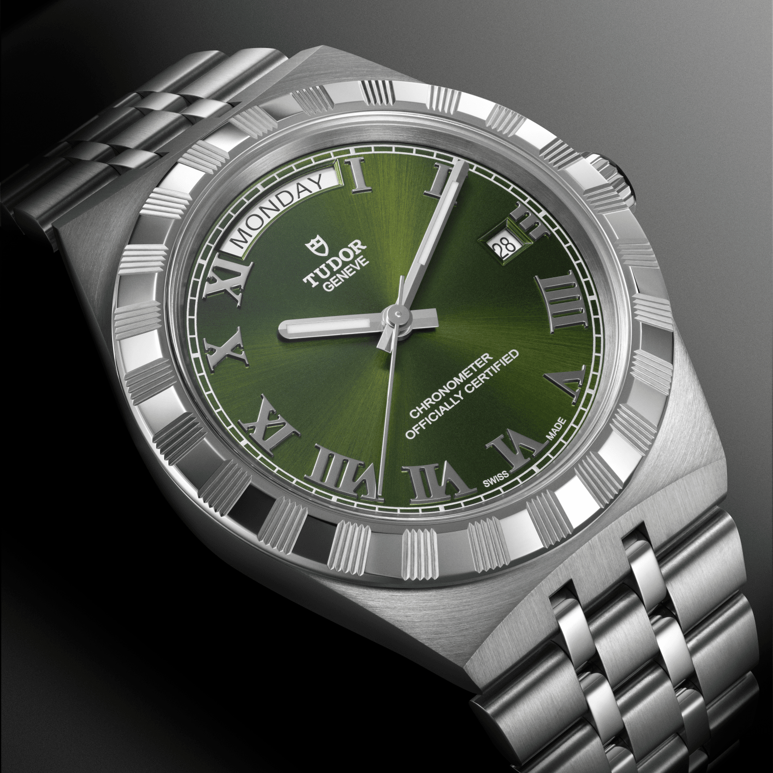 Zilverkleurig polshorloge met groene wijzerplaat, Romeinse cijfers en metalen armband op een grijze achtergrond.
