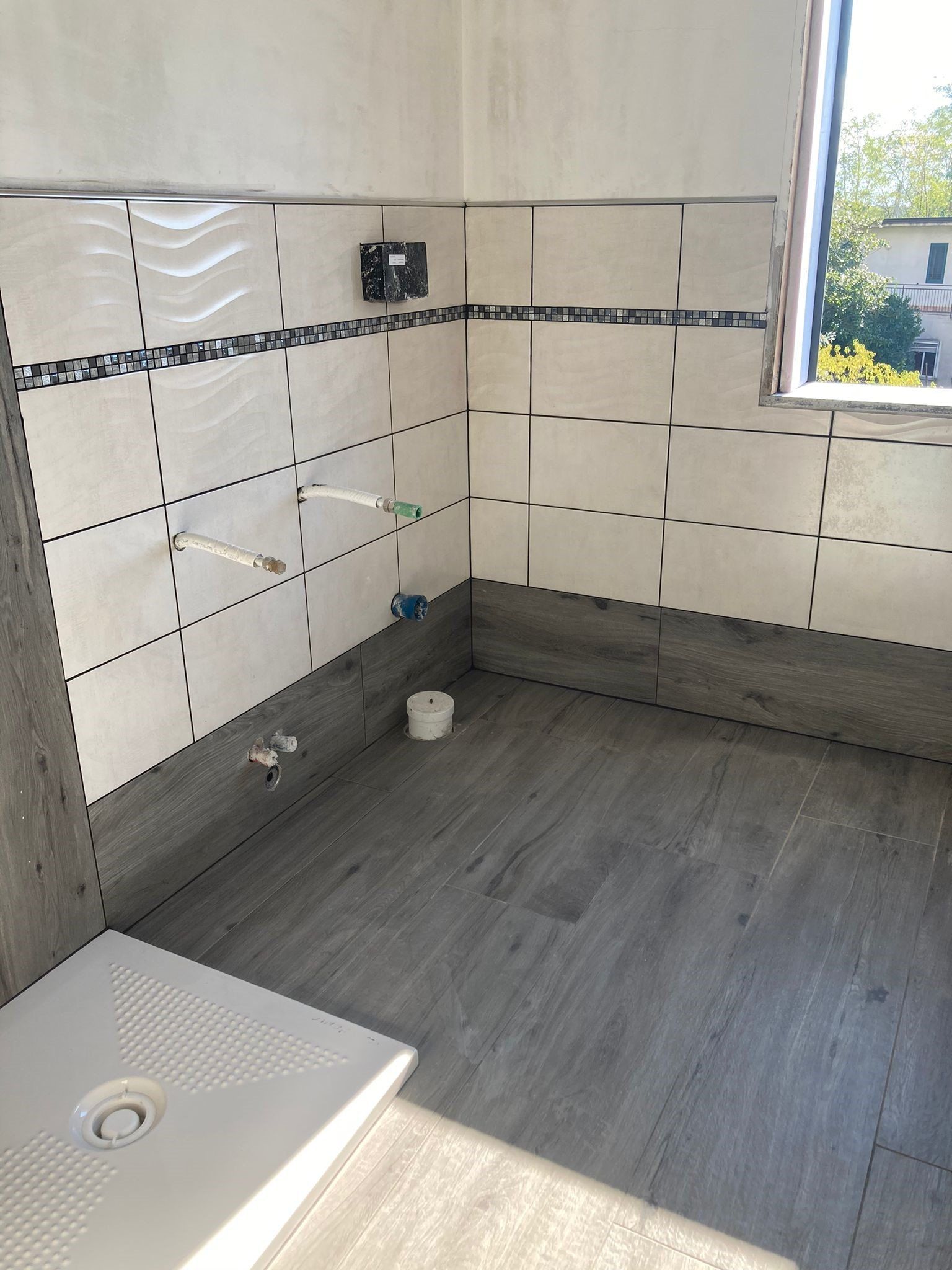 Un bagno con box doccia e finestra.