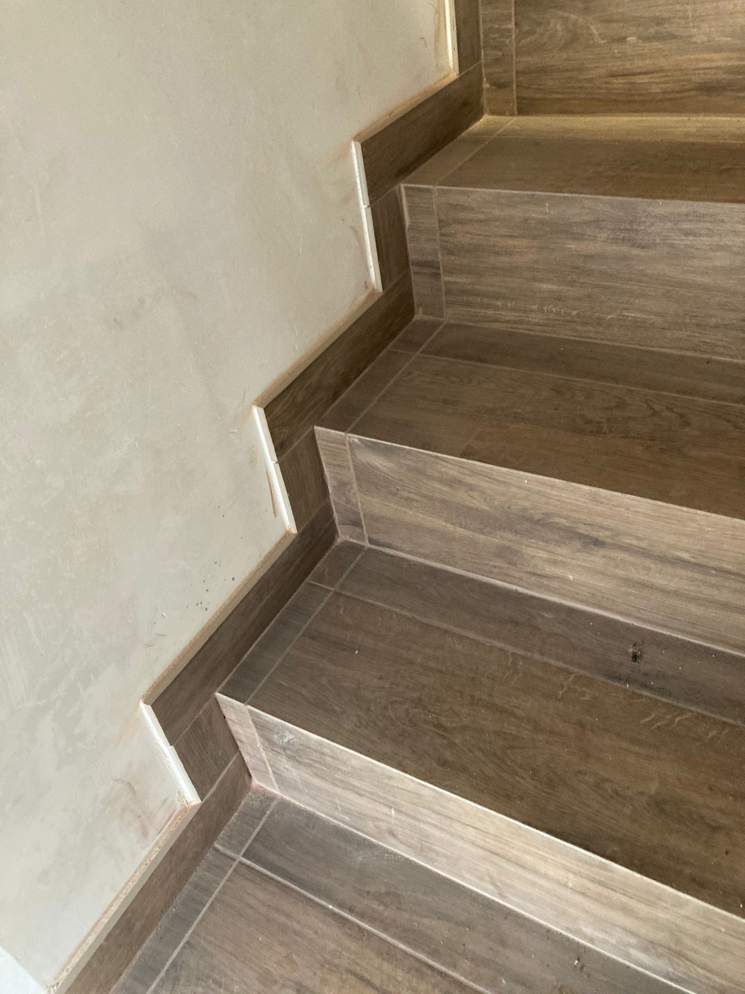 Primo piano di una scala in legno con piastrelle sui gradini.