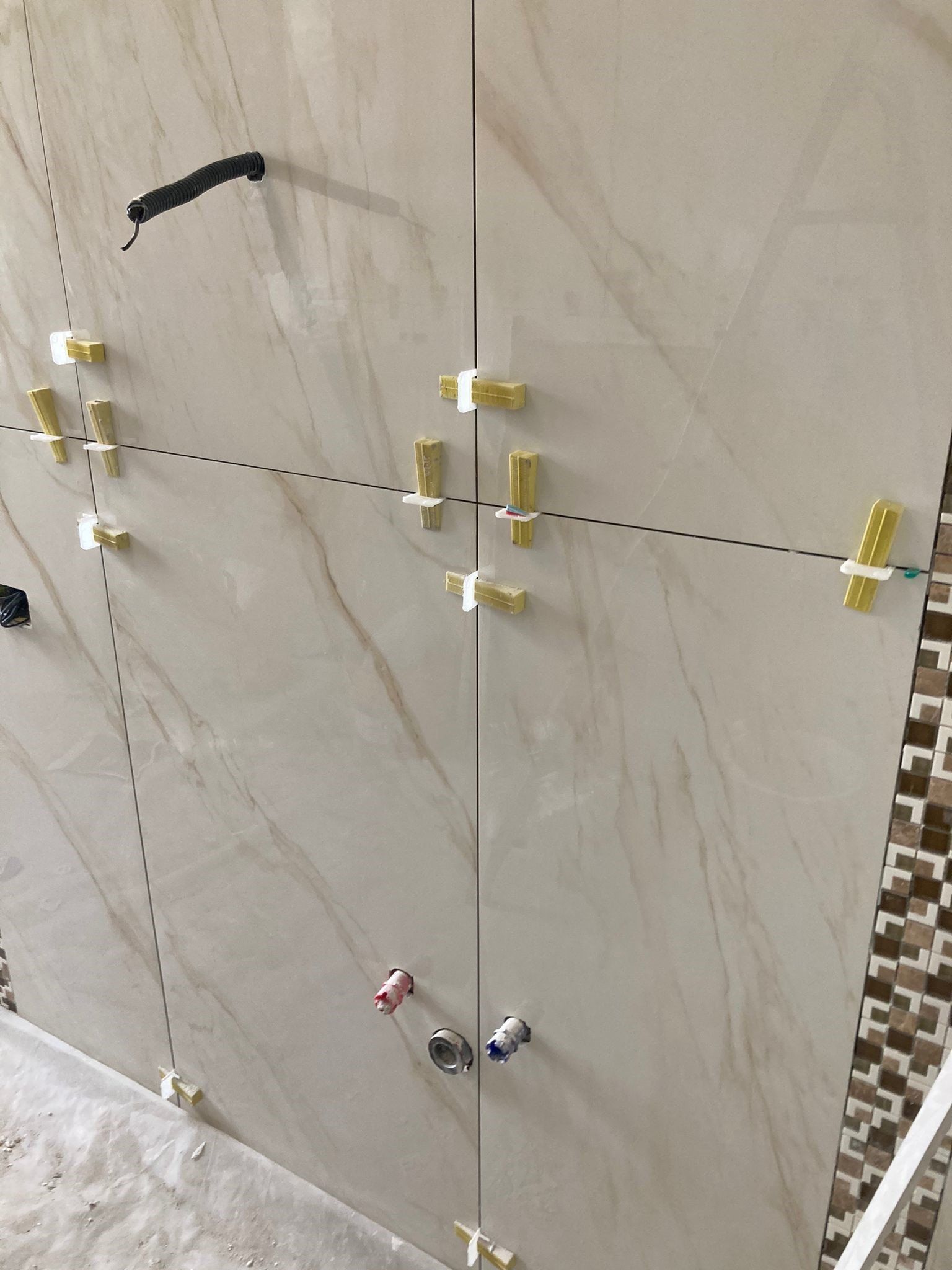 Un primo piano di un muro piastrellato con un sacco di graffette.