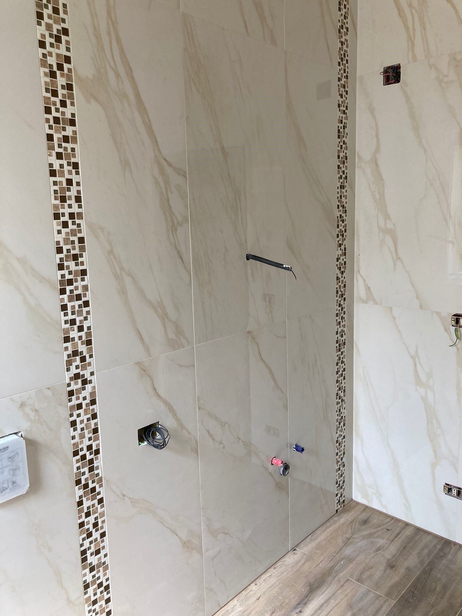 Un bagno con cabina doccia e parete piastrellata.