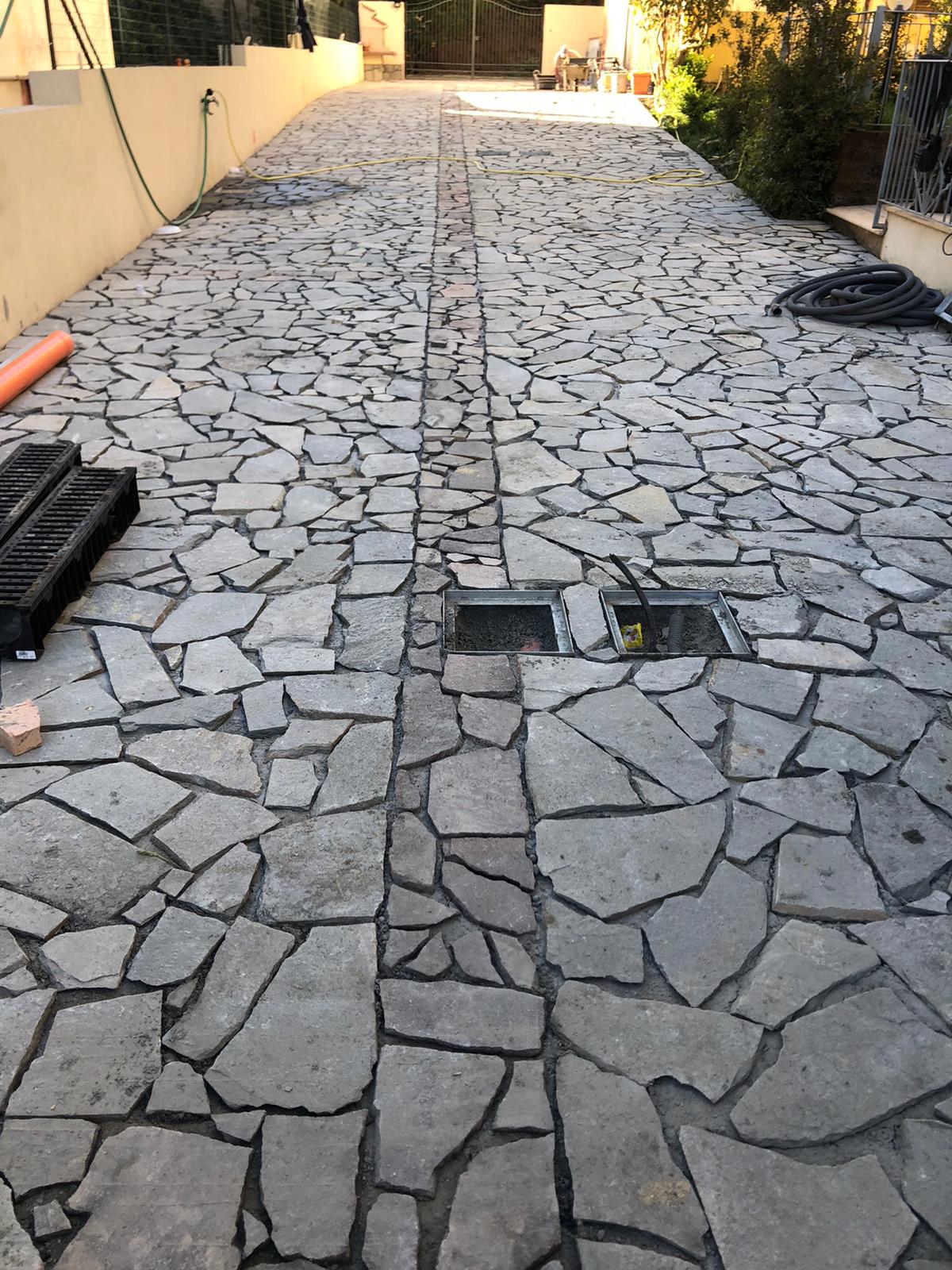 Un vialetto in pietra con uno scarico al centro.